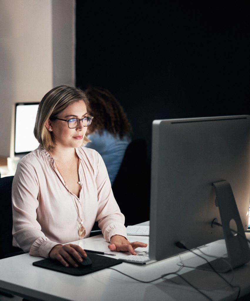 Femme d'affaires qui porte des lunettes Essilor Pro-Office pour se protéger de la lumière bleue devant son ordinateur au travail
