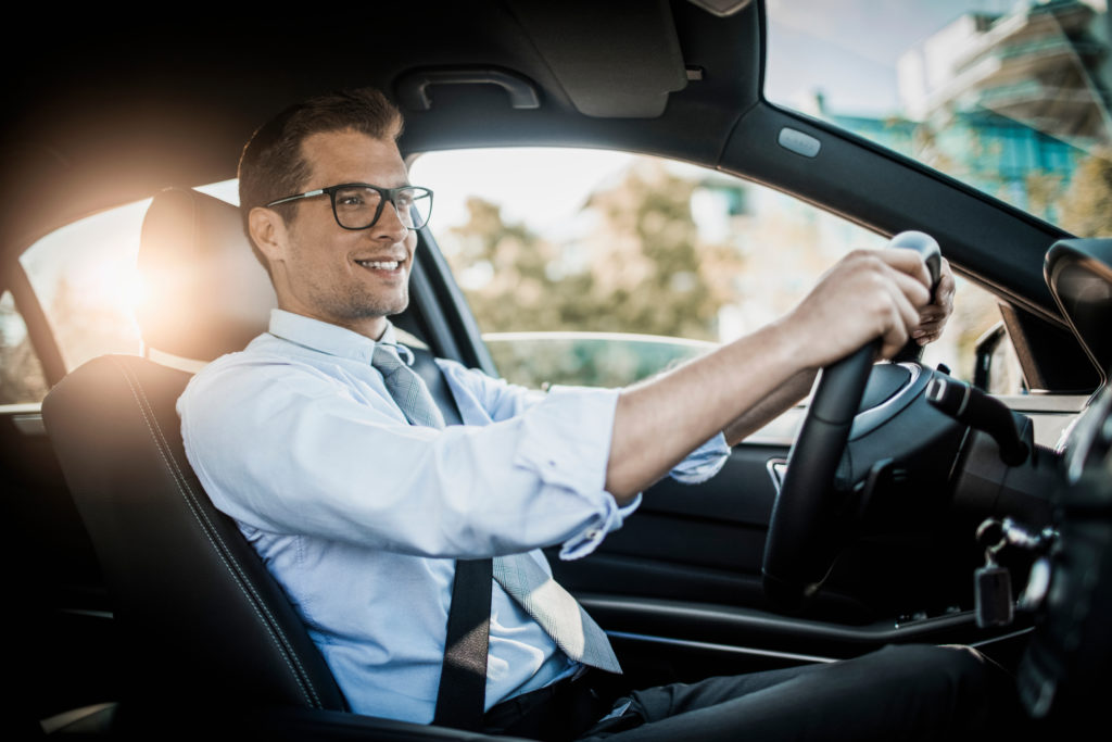 Homme d'affaires au volant qui porte des lunettes pour la conduite Essilor Pro-Drive